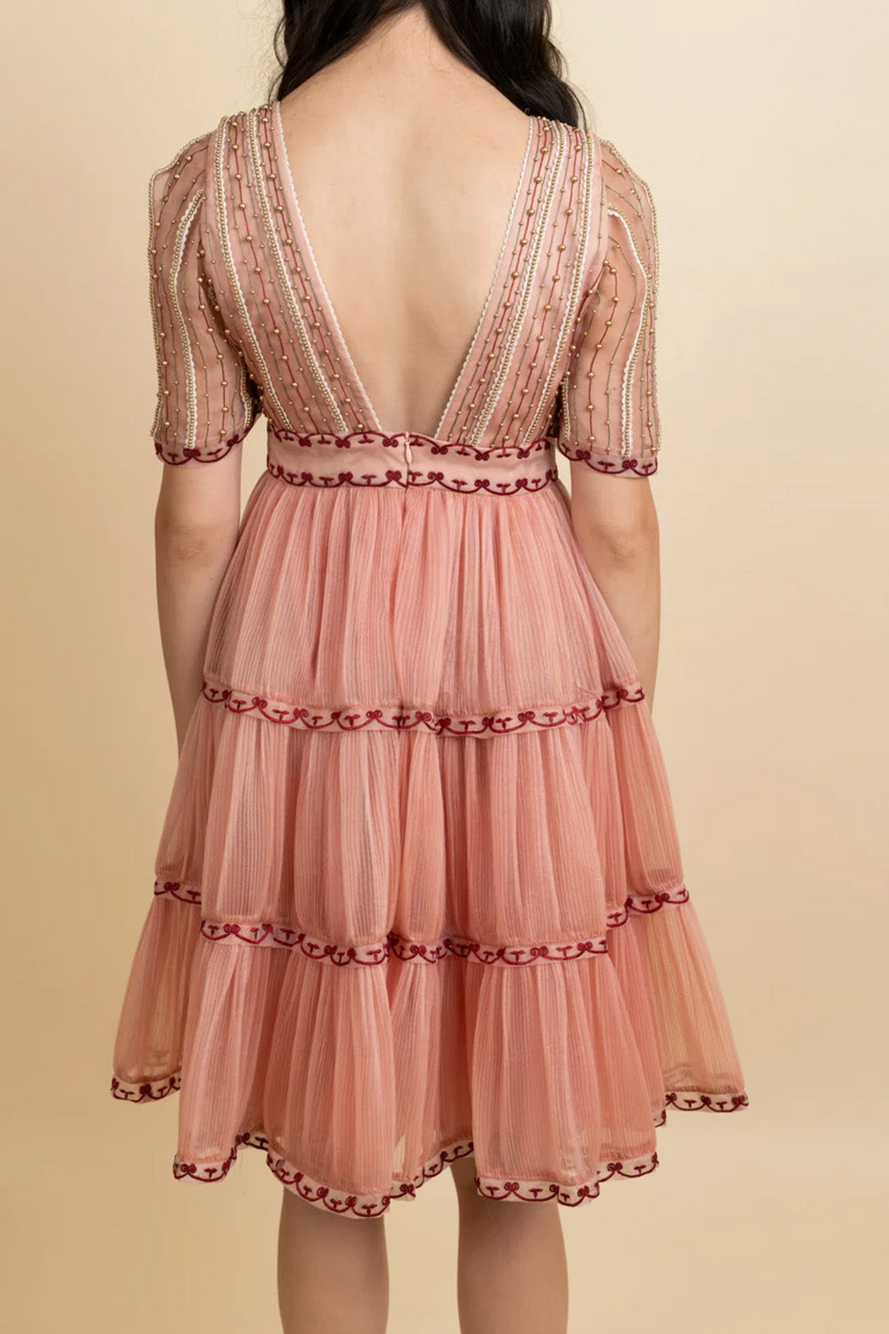 Golden galaxy embroidery in narrow pleated dress.