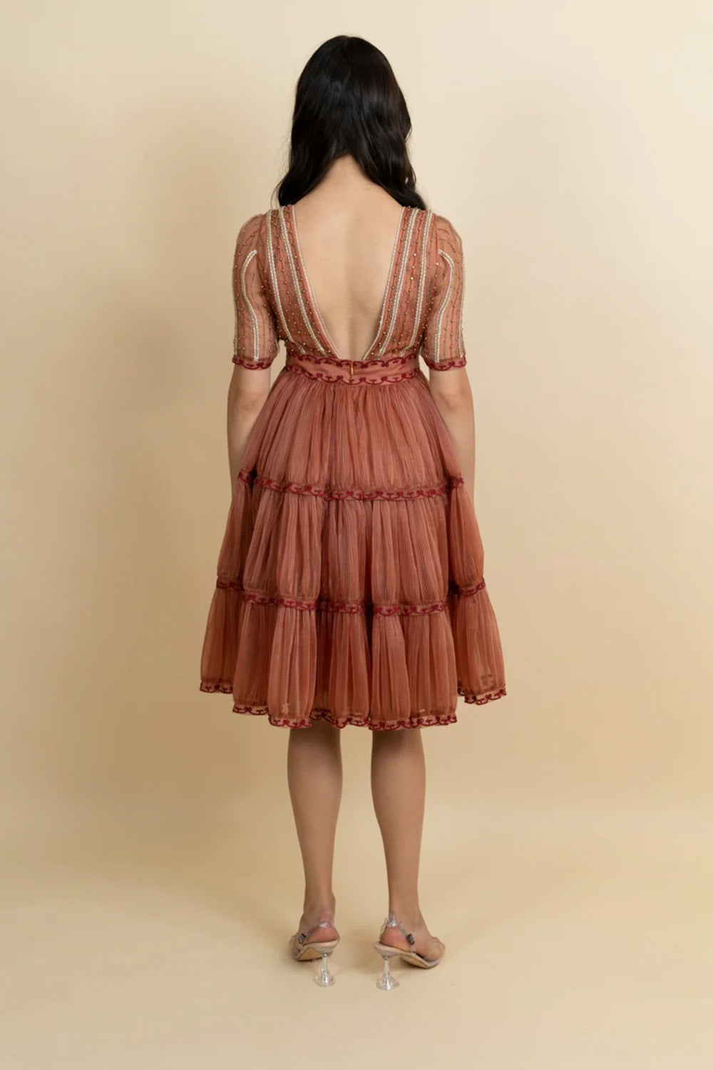 Golden galaxy cinnamon embroidery in narrow pleated dress.
