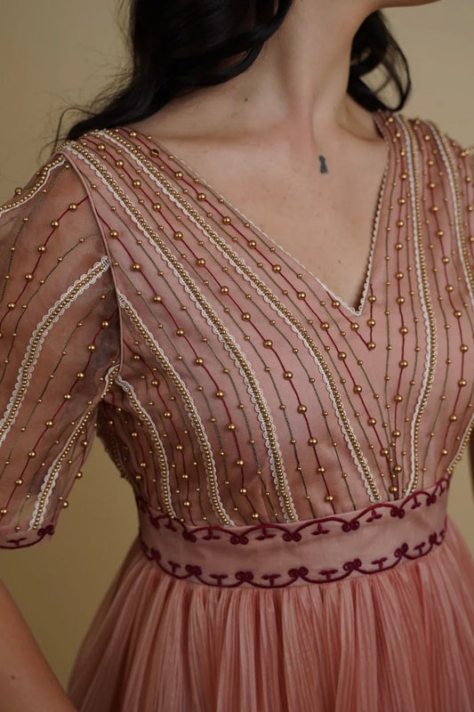 Golden galaxy embroidery in narrow pleated dress.